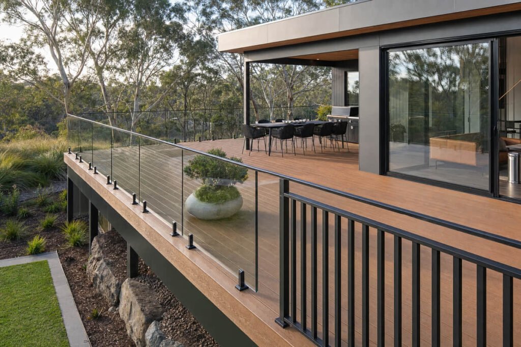 Contemporary Australian outdoor deck combining warm composite boards with slim black balustrades and clear glass panels