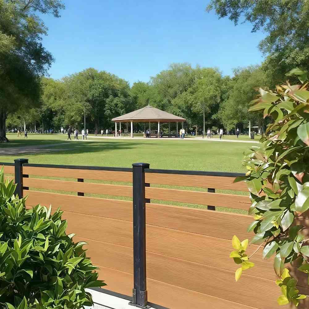 Horizontal light-brown WPC fence panels with black posts by park